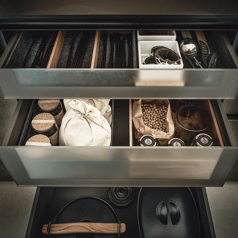Moderne Designküche mit offener Schublade und organisierter Aufbewahrung für Küchenaccessoires – hochwertige Küchenorganisation für exklusive Premiumküchen