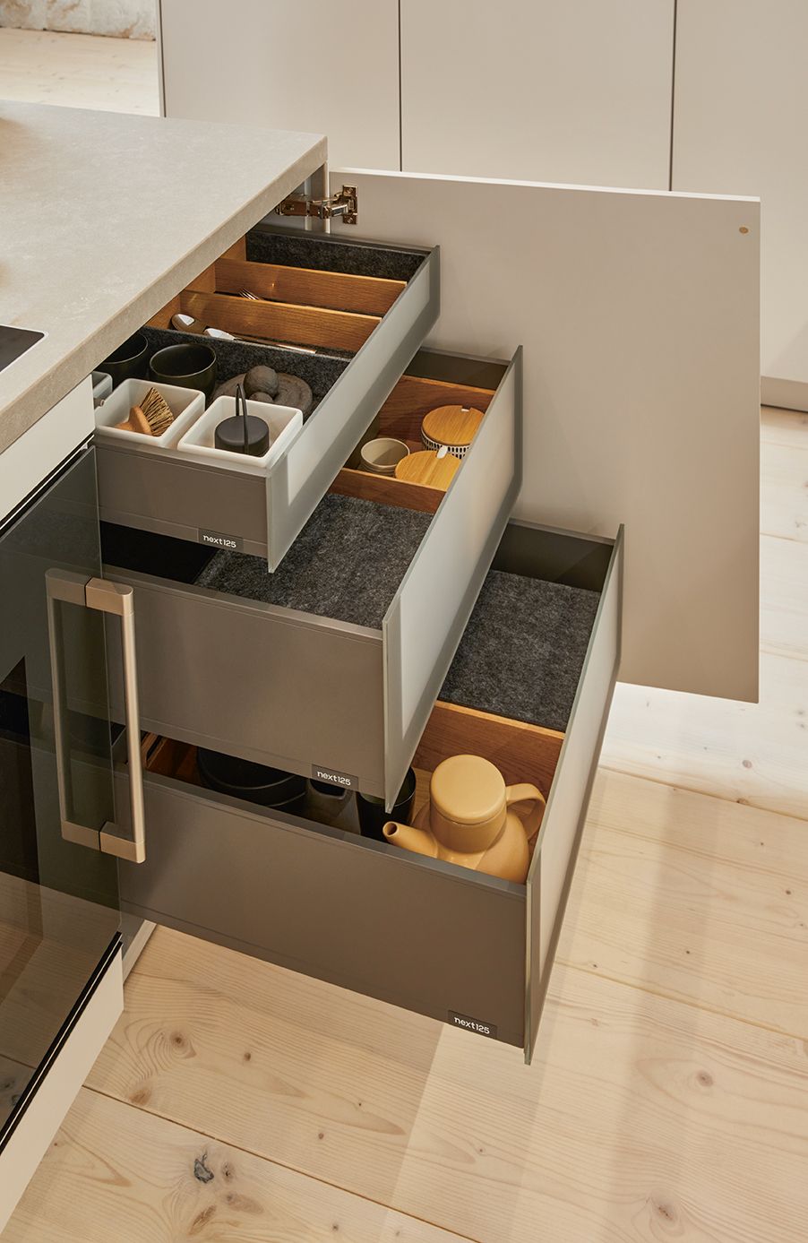 Image of an opened dark next125 base cabinet with interior extractions